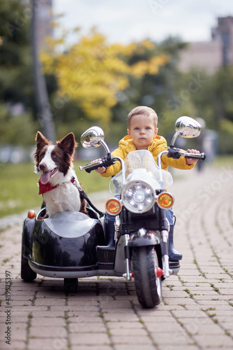 Happy little boy driving a toy motorcycle © luckybusiness