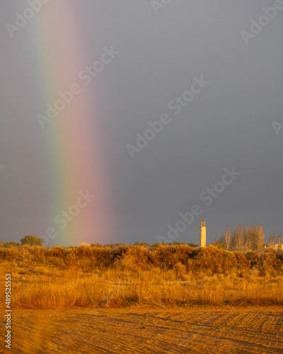 arcoiris al lado de torre de pueblo photo