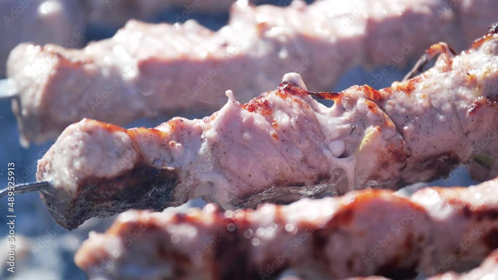 Bbq meat skewers grilling on charcoal grill. Preparation of shish kebab.