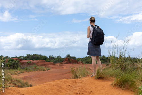 woman with pack pack standing on sand dune © derren