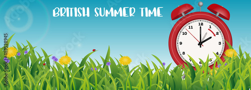 British Summer Time Announcement banner with spring meadow and vintage alarm clock