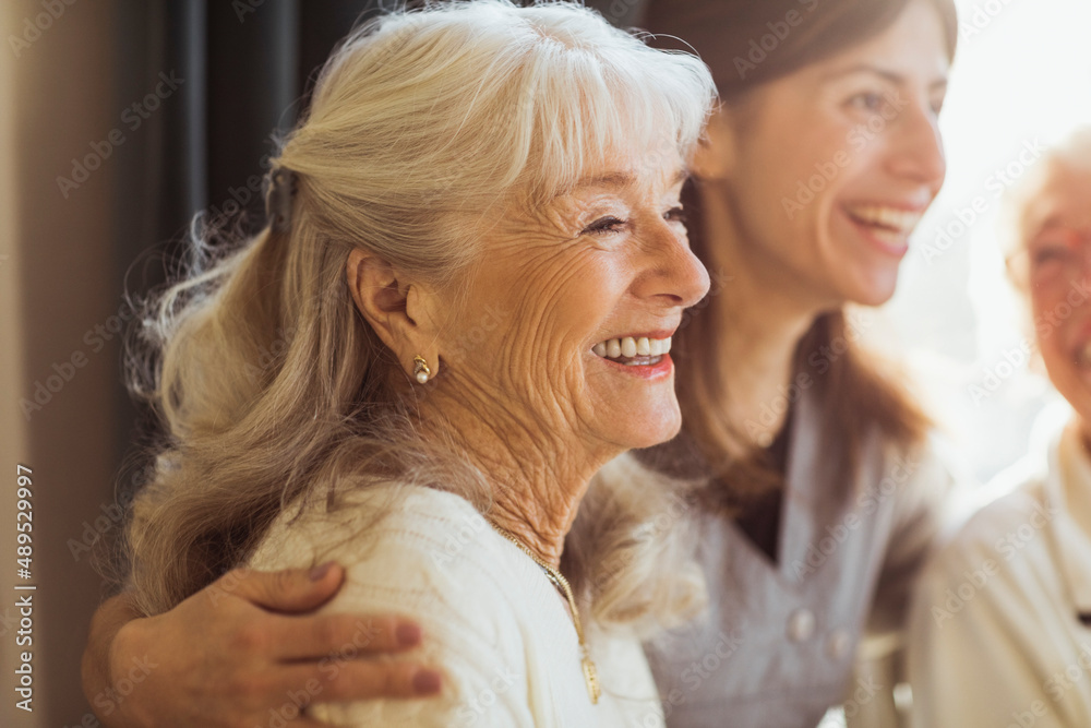 Happy elderly woman by female caregiver at nursing home Happy elderly woman by female caregiver at nursing home