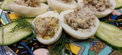 Festive homemade appetizer of boiled eggs and fish with cucumbers. Holidays, cuisine.