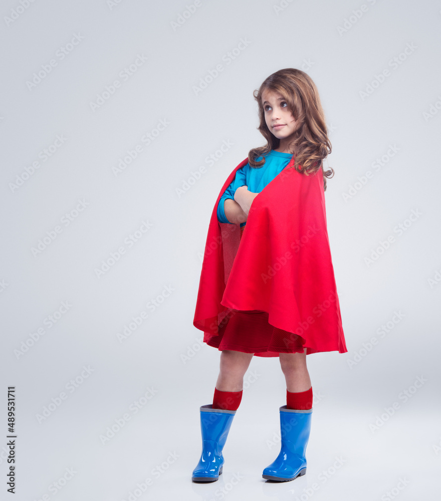 Within every little girl is the courage of a superhero. A studio portrait of a confident young girl dressed as a superhero.