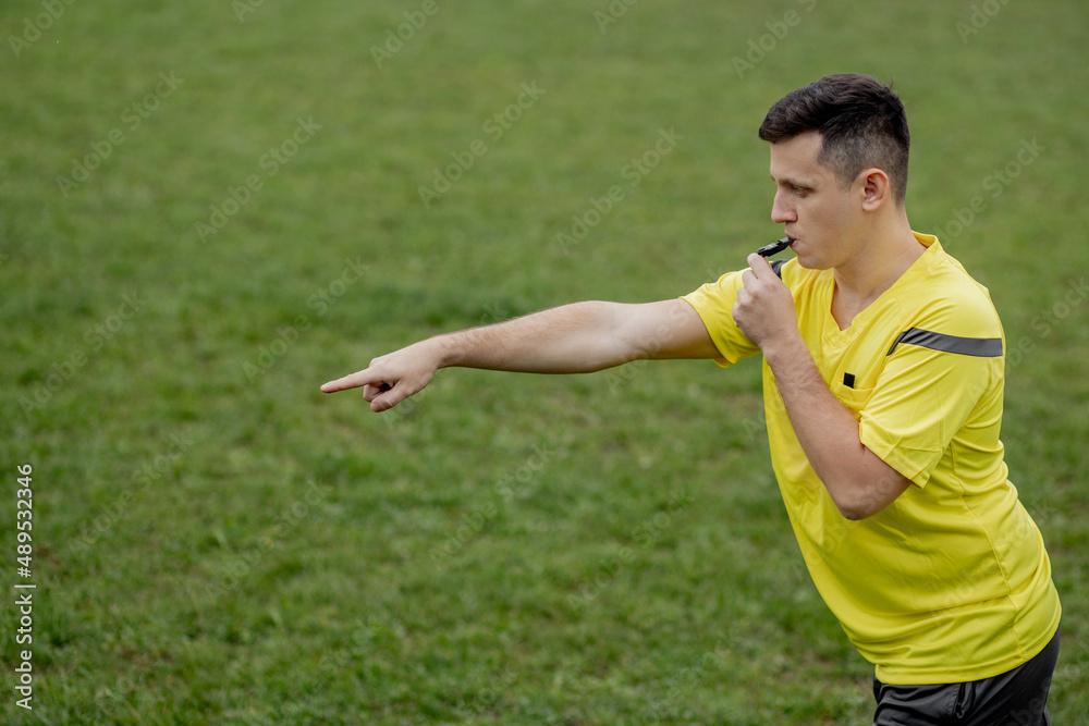 Referee showing on penalty while gaming. Concept of sport, rules violation, controversial issues, obstacles overcoming. Referee showing on penalty while gaming. Concept of sport, rules violation, controversial issues, obstacles overcoming.