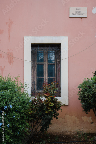 schönes altes Fenster aus Holz mit Büschen und Bäumen auf der sonnigen griechischen Insel Kreta
