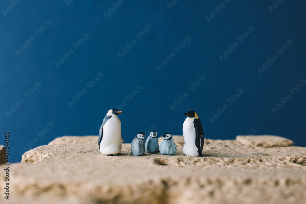 Fototapeta premium Cute miniature toy penguin colony. Wild animal family.