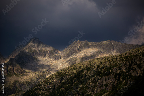 spot of sunlight in the mountains with stormy sky