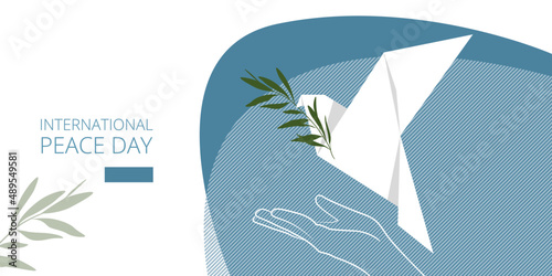 The white dove of peace flies from the palm of the hand with an olive branch in its beak. Origami. A symbol of peace. Landing page template, presentation, banner for the International Day of Peace.