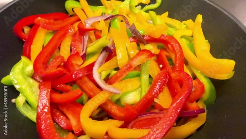 Closeup, green, red and yellow peppers simmering in the pan, for a healthy recipe, concepts, 4k resolution