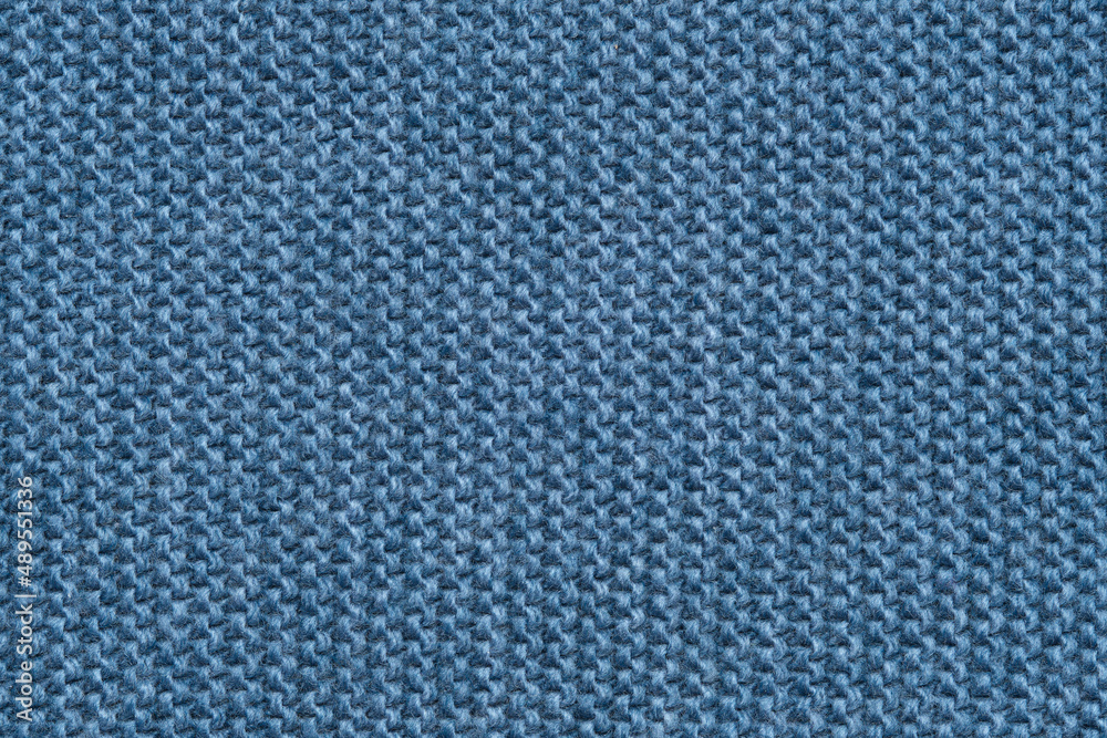 Blue knitted texture of a scarf or background of a winter sweater. Blue knitted texture of a scarf or background of a winter sweater.