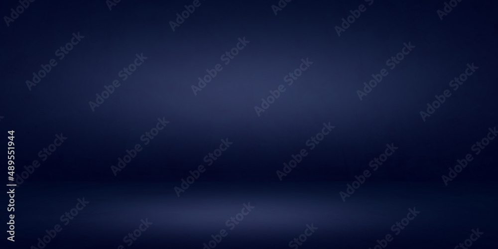 Dark blue cement wall studio background and rough floor soft lighting circular well editing montage products and text present on empty free space backdrop  