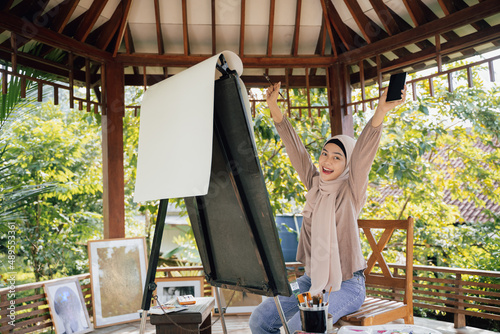 muslim painter is painting in her workshop excitedly photo