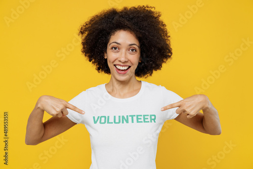 Fotografija Young smiling woman of African American ethnicity wears white volunteer t-shirt point finger on herself isolated on plain yellow background