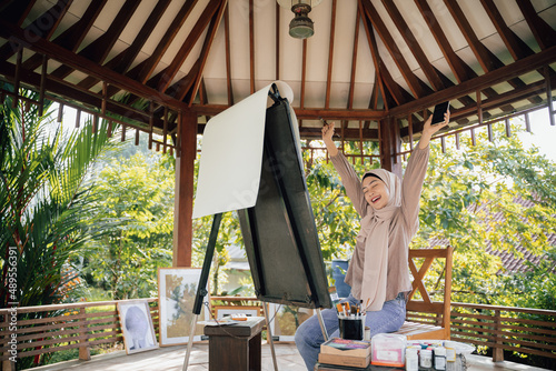 muslim painter is painting in her workshop excitedly photo