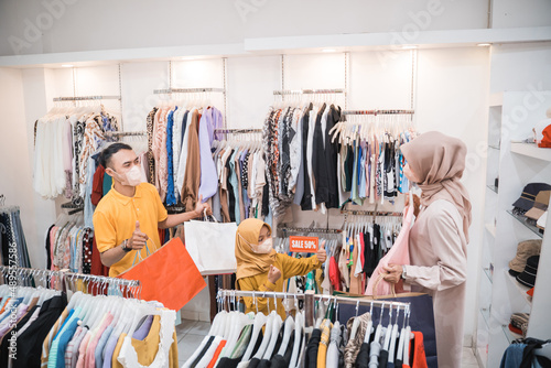 muslim family buying new clothes for eid mubarak at the mall