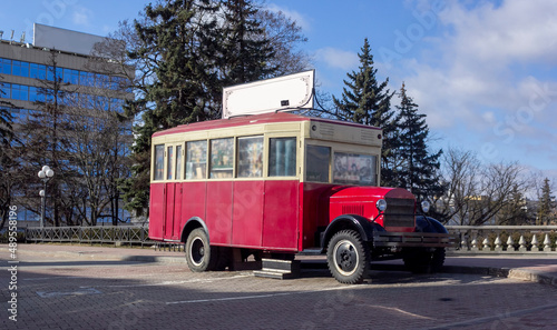 Old retro red bus in Europe. Rusty rough metal surface texture. Antique vintage soviet automobile bus. Side view.