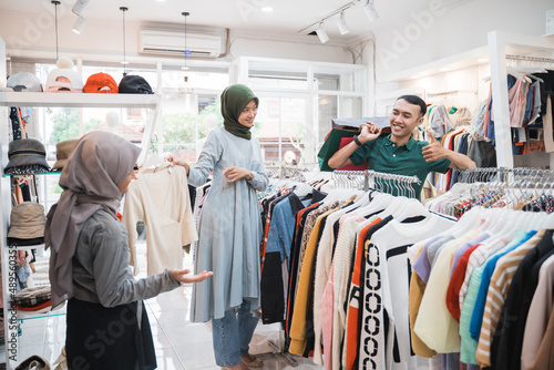 asian muslim family buying new clothes together in clothing store
