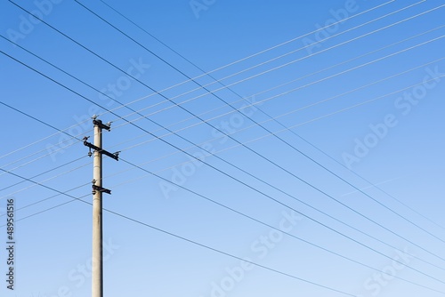 High voltage columns, in the background with blue sky and clouds. Prices of electricity, consumption, ecology. © Mario