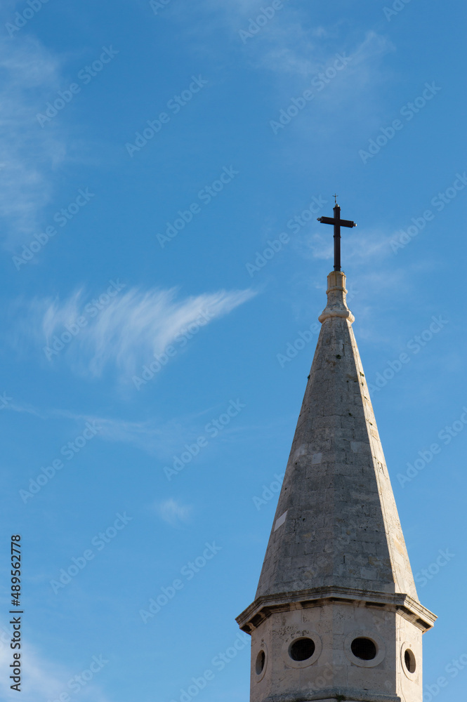 Top of stone church tower with holy cross, symbol of Catholicism, religious concept Top of stone church tower with holy cross, symbol of Catholicism, religious concept