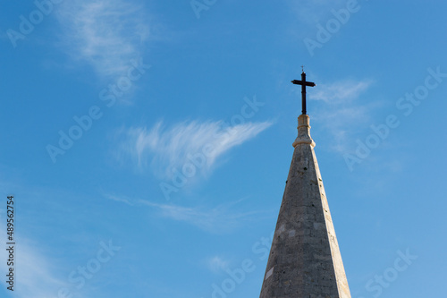 Top of stone church tower with holy cross  symbol of Catholicism  religious concept