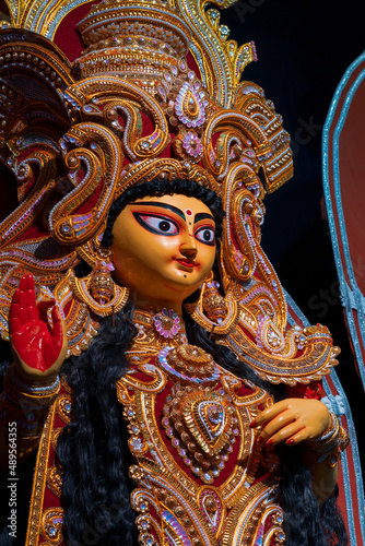 Face of Goddess Laxmi at decorated Durga Puja pandal, Durga Puja festival at night. Shot under colored light at Howrah, West Bengal, India.