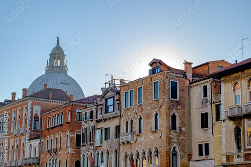 sunset behind houses nearby canale grande in venice, italy
