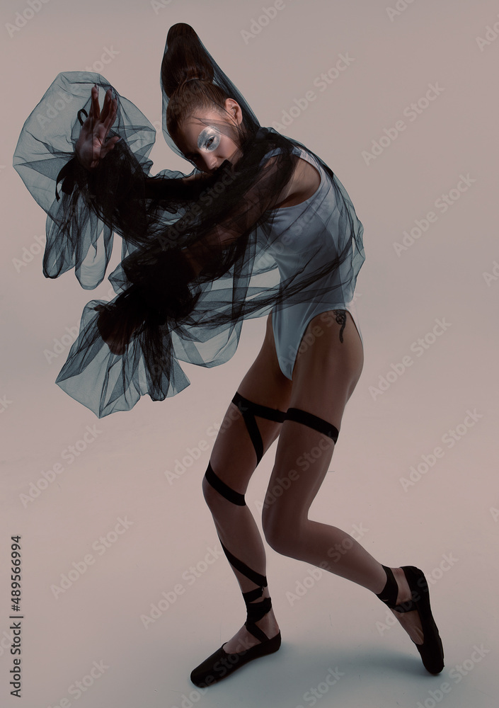 Fashion ballerina with art makeup and hair poses in the studio 