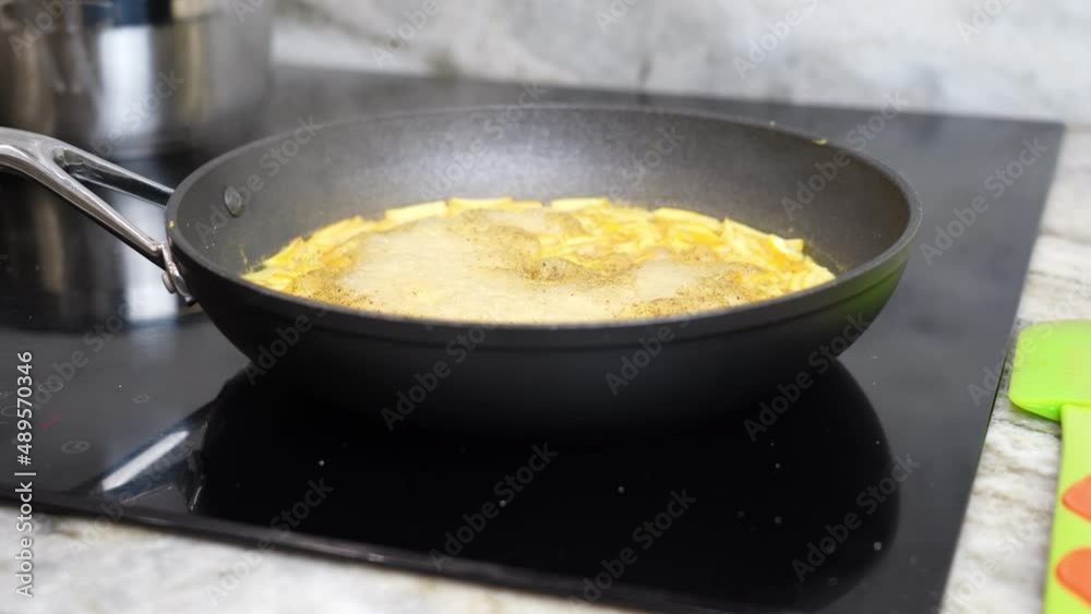 frying pan on a ceramic hob with evaporating slices of orange citrus peel for making sauce for meat frying pan on a ceramic hob with evaporating slices of orange citrus peel for making sauce for meat