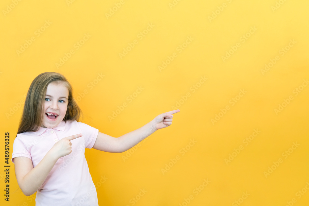 Wow, look, advertise here! Portrait of an amazed cute girl pointing at an empty space in the background Wow, look, advertise here! Portrait of an amazed cute girl pointing at an empty space in the background