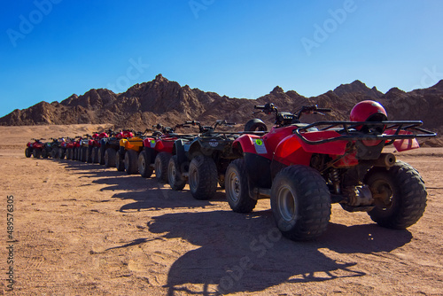 ATVs on Egyptian sand desert. Quad bike in Nabq protected area near mountains, Sharm El Sheikh, Sinai, Egypt, Africa. Safari, popular egyptian excursion, off-road ATV adventures in a desert photo