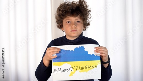 Boy child 7 years old protest against the war between Russia and Ukraine with sign stop war on a flag  - start of the conflict in Europe in territories close to NATO
