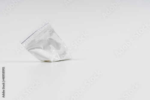 Cocaine in a plastic bag on a white background with copy space.