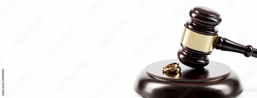 Wedding rings on the figure of a broken heart from a tree, hammer of a judge. Divorce divorce proceedings. Judge hammer wedding ring with copy space