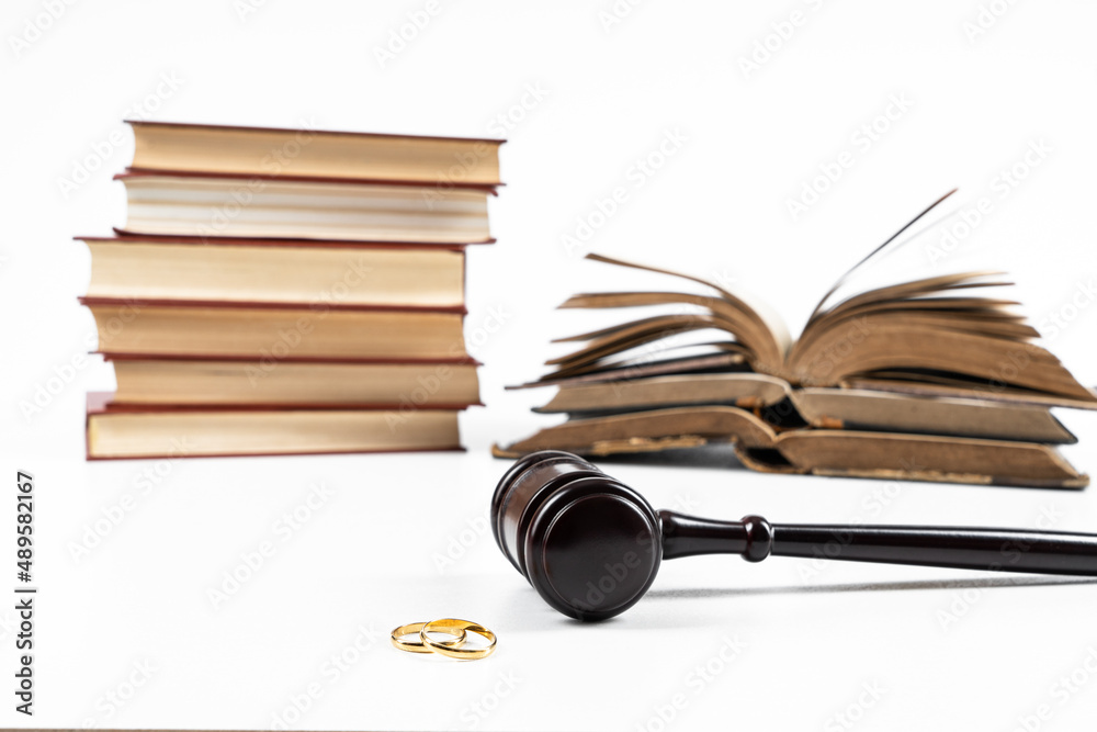Law and Justice concept. Judge gavel on white background with two golden wedding rings Law and Justice concept. Judge gavel on white background with two golden wedding rings