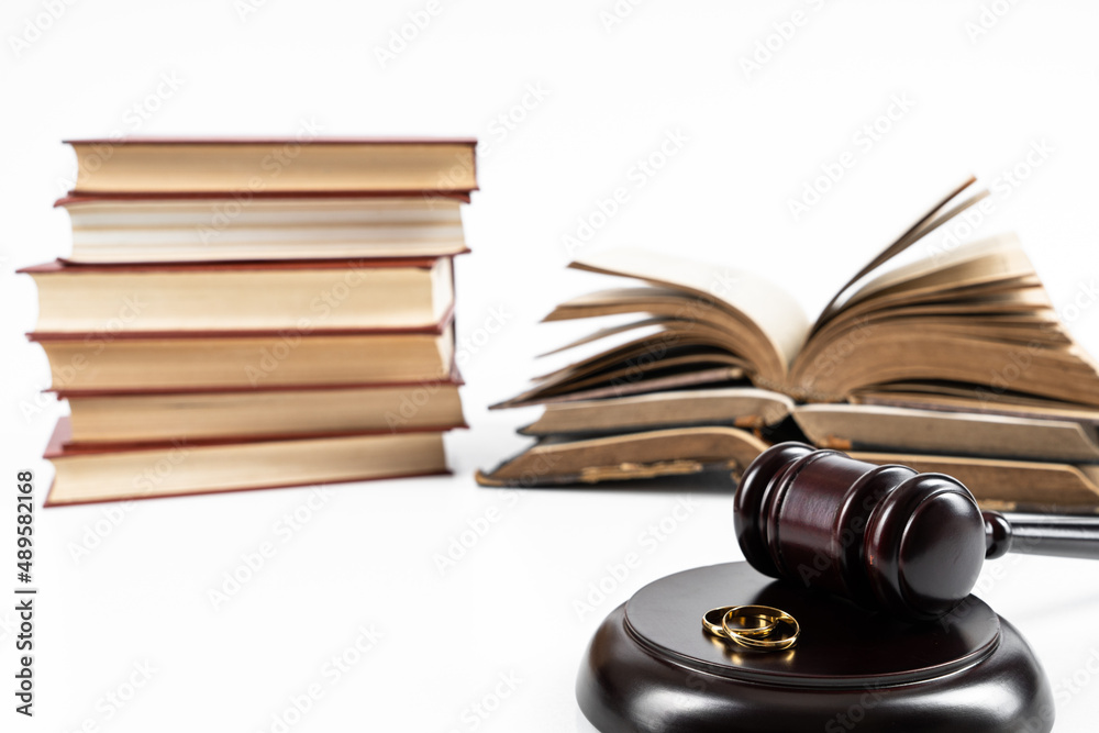 Law and Justice concept. Judge gavel on white background with two golden wedding rings Law and Justice concept. Judge gavel on white background with two golden wedding rings