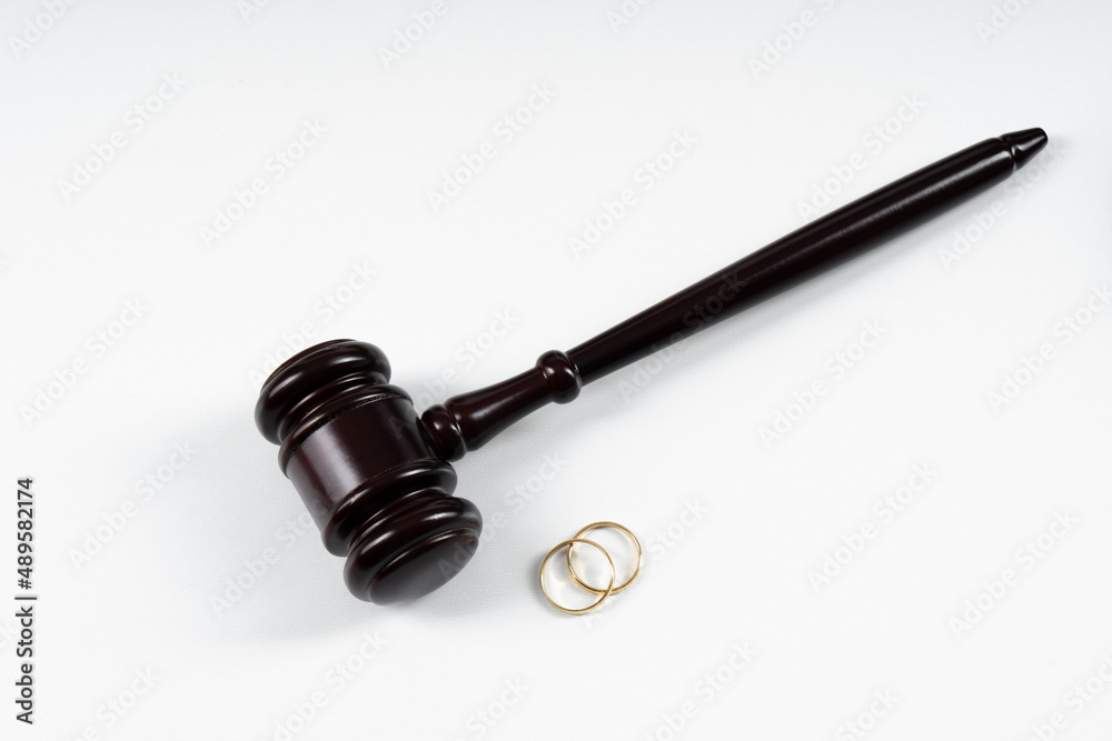 Wedding rings on the figure of a broken heart from a tree, hammer of a judge. Divorce divorce proceedings. Judge hammer wedding ring with copy space Wedding rings on the figure of a broken heart from a tree, hammer of a judge. Divorce divorce proceedings. Judge hammer wedding ring with copy space