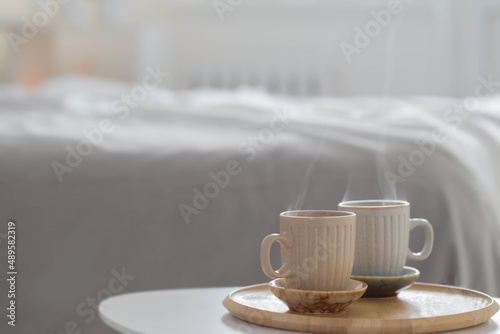 two cup of coffee on wooden tray in bedroom