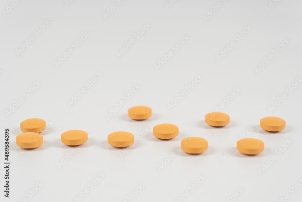 Yellow vitamins or pills on white background, macro, close-up, copy space. Nutritional supplements concept, health, vitamins Yellow vitamins or pills on white background, macro, close-up, copy space. Nutritional supplements concept, health, vitamins