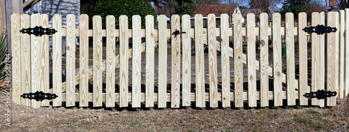New unpainted picket fence with gate.