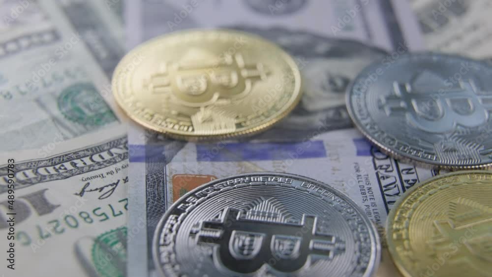 bitcoin coins lie on dollars from above close-up bitcoin coins lie on dollars from above close-up
