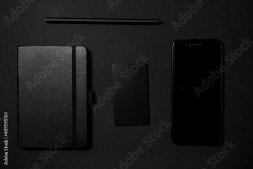 Mock up business template. Black blank business card stationery on black desktop with office supplies