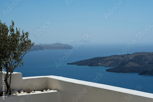 Beautiful big terrace with trees and a breathtaking view over the volcano and the aegean sea in Santorini Greece 