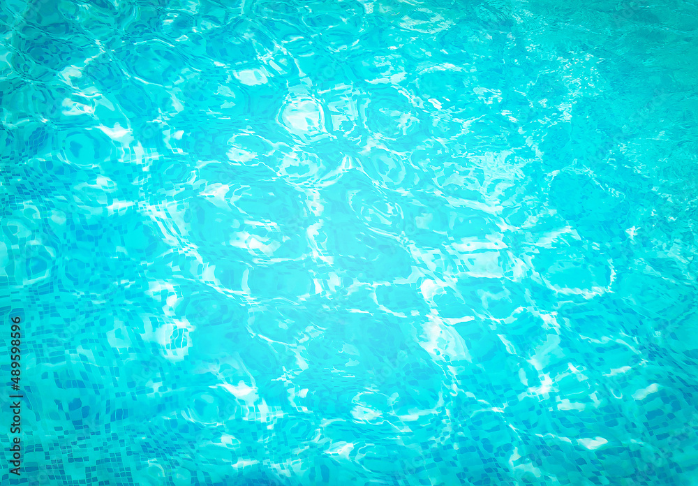 Abstract water in swimming pool. Shining sun reflection, motion of ripple wave. Background of water surface. Summer, sport, relax, vacation concept.