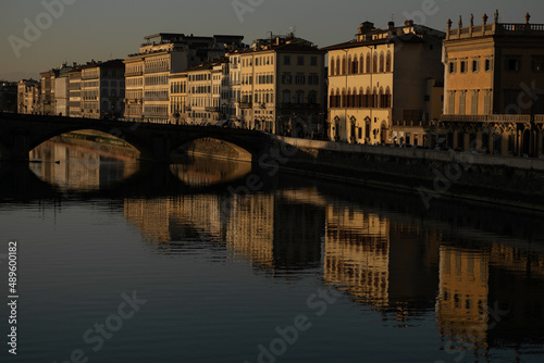 Buildings near the Arno river with water reflections in Florence, Italy