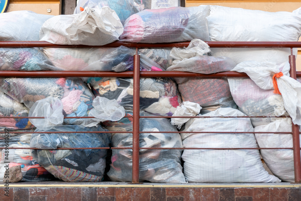 old used clothes in plastic bags. New arrival of the goods in the second-hand store. Humanitarian aid for children affected by the war in Ukraine.