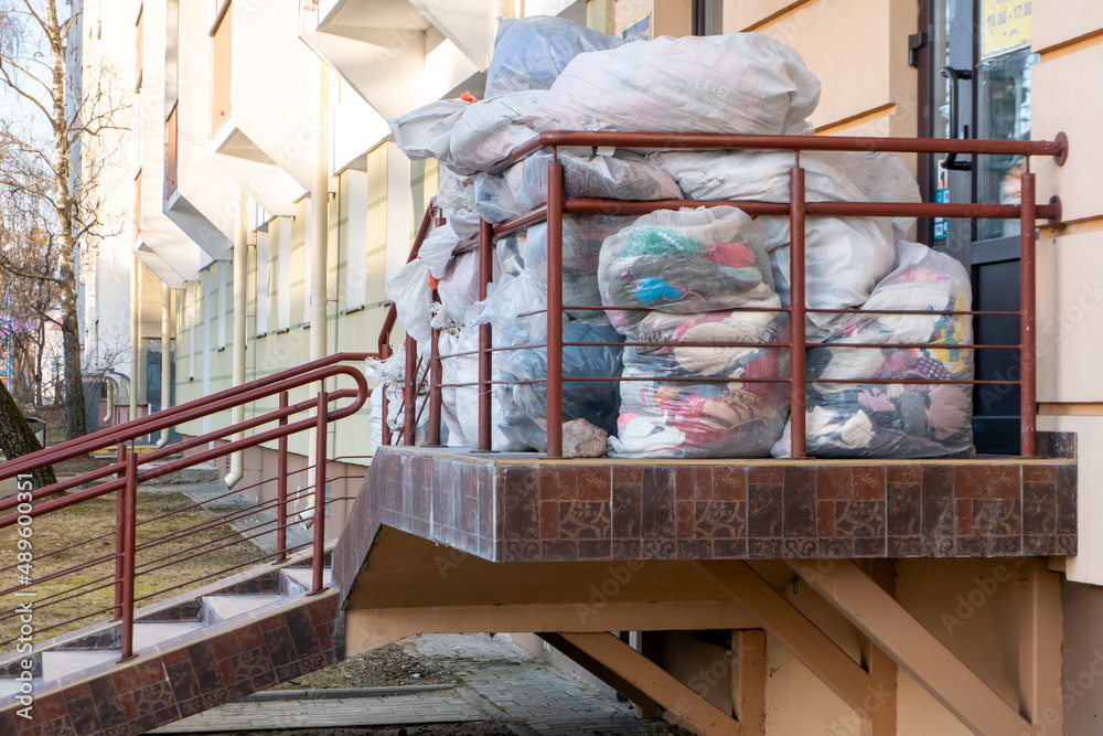 old used clothes in plastic bags. New arrival of the goods in the second-hand store. Humanitarian aid for children affected by the war in Ukraine. old used clothes in plastic bags. New arrival of the goods in the second-hand store. Humanitarian aid for children affected by the war in Ukraine.