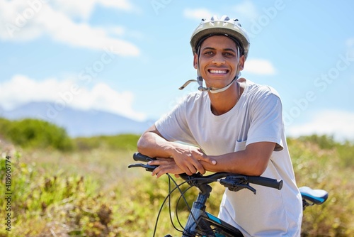 Living life in the fast lane. Shot of a young man sitting on his bike in nature.