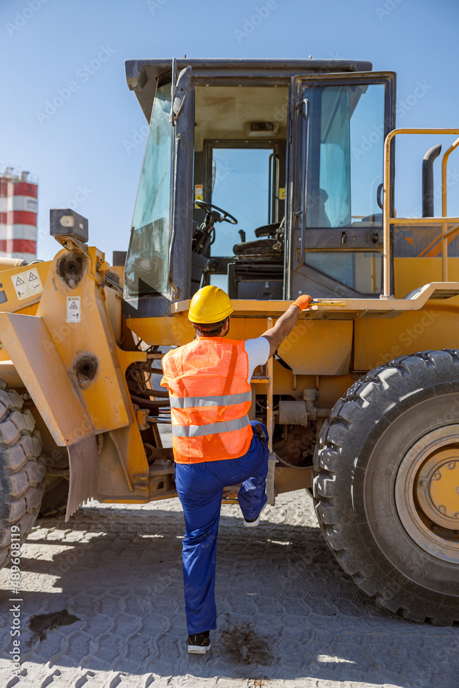 Experienced construction worker using truck at factory