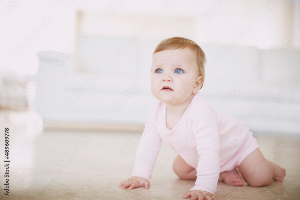 Exploring the floor- baby crawling. Shot of a little baby girl crawling on the floor indoors. Exploring the floor- baby crawling. Shot of a little baby girl crawling on the floor indoors.